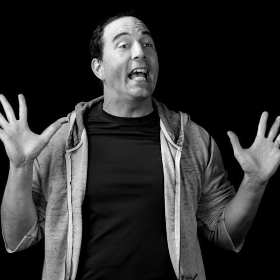 A black and white educational photo of a man with his hands out, providing an overview.