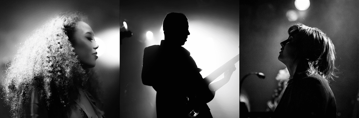 A black and white photo of a group of people in a dark room.