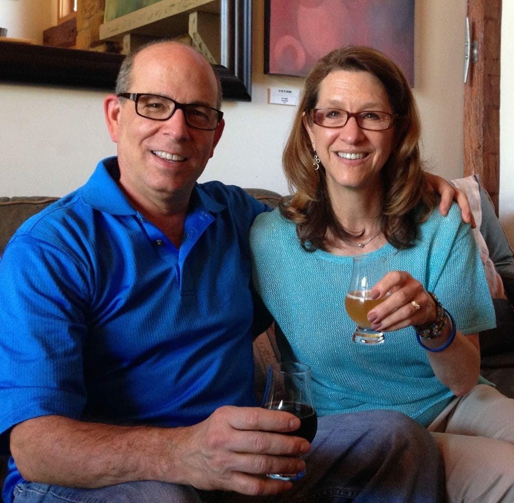 Donor Spotlight: A man and woman sitting on a couch holding a glass of wine, showcasing their generous contribution.