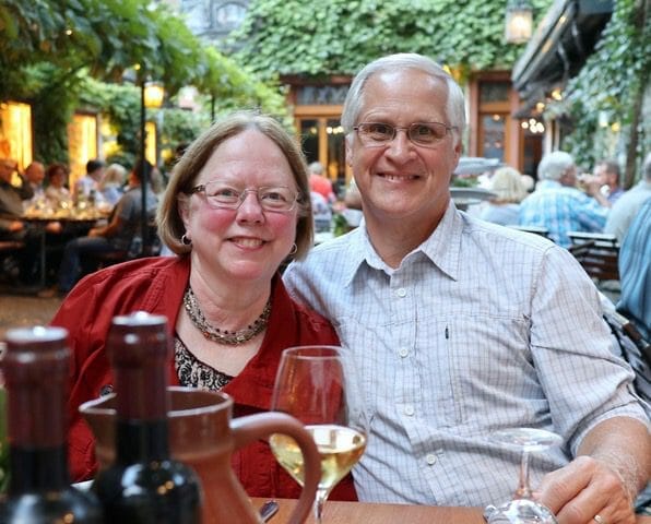 Peggy & Steve Yoder, a couple in the donor spotlight, sitting at a table with wine glasses.